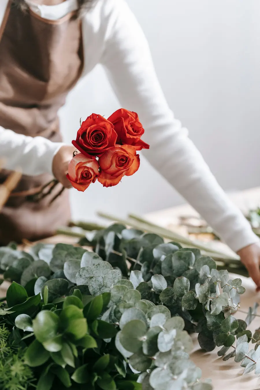 Sample image: a florist’s hands wrapping red roses